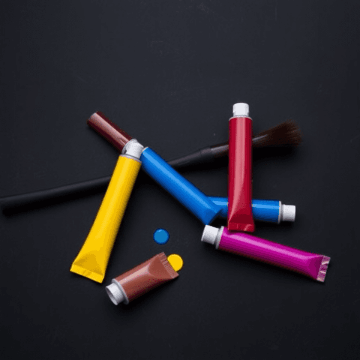 Latar belakang hitam yang ramping dengan tekstur halus, menampilkan tabung cat berwarna merah, biru, kuning, magenta, dan cyan yang disusun secara ...